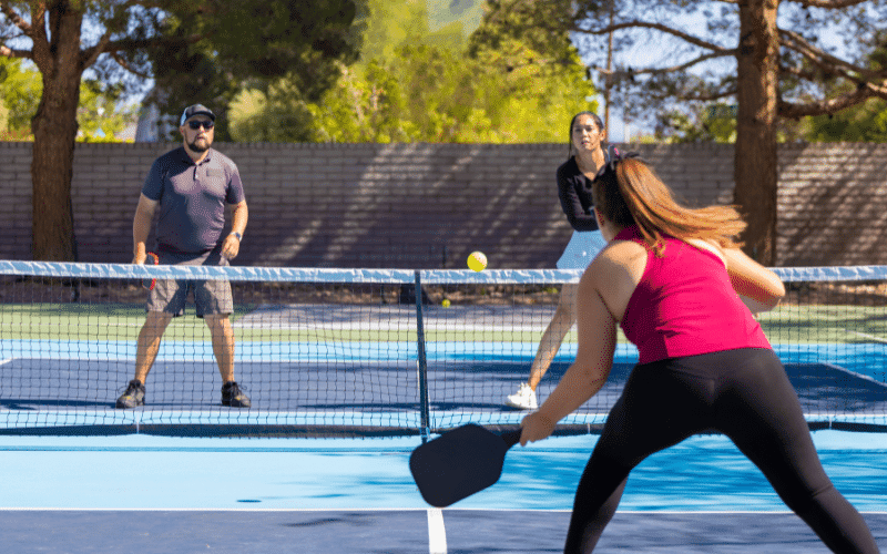 A group of players engage in various pickleball game variations, demonstrating beginner rules and strategies